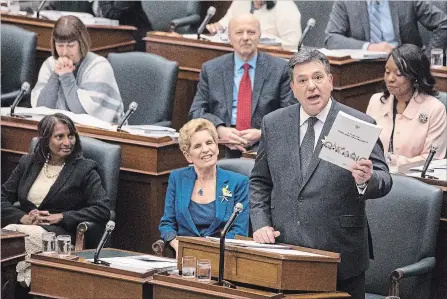  ?? CHRIS YOUNG THE CANADIAN PRESS ?? Ontario’s Premier Kathleen Wynne sits next to Finance Minister Charles Sousa, right, as he tables the provincial budget.