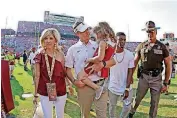  ?? [PHOTO BY BRYAN TERRY, THE OKLAHOMAN] ?? Lincoln Riley walks off Owen Field on Saturday with wife Caitlin and daughter Sloan after his first game as the OU head coach.