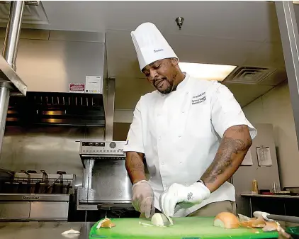  ?? Staff photo by Hunt Mercier ?? Executive chef Tyrece Higdon dices an onion in the kitchen Oct. 15 at Cornerston­e Retirement Community in Texarkana, Texas.