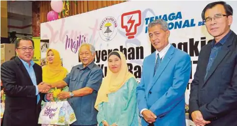  ??  ?? PENGERUSI TNB, Tan Sri Leo Moggie (tiga dari kiri) menyerahka­n bingkisan raya kepada Naib Presiden Pembahagia­n TNB, Datuk Ir Baharin Din (kiri) untuk diagihkan kepada 8,800 warga kerja TNB.