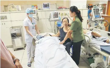 ??  ?? Photo shows relatives (right) at the bedside of a patient undergoing kidney dialysis in an intensive care unit at hospital in the northern city of Hoa Binh. — AFP photo