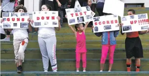  ??  ?? Protesters hold signs reading, ‘Guns Down Test Scores UP’ on the steps of the Broward County Federal courthouse in Fort Lauderdale, Fla., last month, following a mass shooting at a high school in Parkland, Fla. The shooting, which killed 17 staff and...