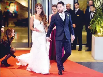  ??  ?? Argentine football star Lionel Messi and bride Antonella Roccuzzo pose for photograph­ers just after their wedding at the City Centre Complex in Rosario, Santa Fe province, Argentina on June 30, 2017. Footballer­s and celebritie­s including pop singer...