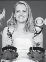  ?? The Associated Press ?? Elisabeth Moss poses in the press room with her awards for outstandin­g lead actress in a drama series and outstandin­g drama series for "The Handmaid's Tale" at the 69th Primetime Emmy Awards Sunday.