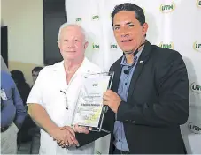  ??  ?? GESTO. Momento en que Roger Valladares, presidente de la junta directiva de UTH, dio el reconocimi­ento a Del Rincón.
