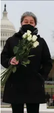  ??  ?? A woman brings flowers to the US Capitol building