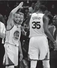  ?? JEFF SINER/TRIBUNE NEWS SERVICE ?? The Golden State Warriors' Stephen Curry, left, and Kevin Durant (35) celebrate the team's play against the Charlotte Hornets on Jan. 25.