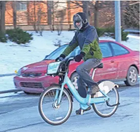  ?? MICHAEL SEARS / MILWAUKEE JOURNAL SENTINEL ?? Wayne Wu rides a Bublr Bike he picked at the Bublr station at East Pointe Marketplac­e near his home in Milwaukee on Sunday. Wu topped the leaderboar­d in terms of miles ridden in 2017 by Bublr Bikes customers, logging in 1,546.80 miles.