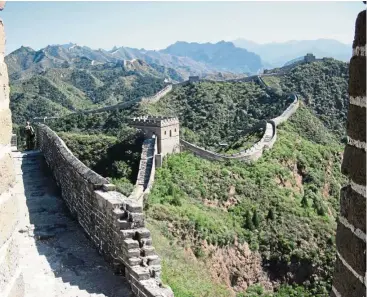  ??  ?? The Great Wall snakes through the mountains at Jinshanlin­g.