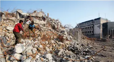  ?? (Khalid al-Mousily/Reuters) ?? HOMELESS BOYS SEARCH for scrap in the remains of a building in Mosul, Iraq last week.