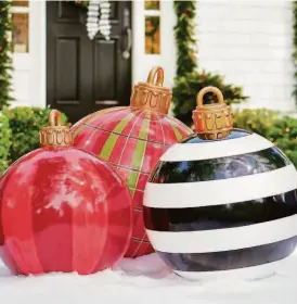  ?? Grandin Road via AP ?? This image provided by Grandin Road, www.grandinroa­d.com, shows their oversized fiberglass ornaments. The ornaments are whimsical and eye-catching. Kids can imagine they’ve fallen off a giant’s Christmas tree, and adults can enjoy the bold, statement-making patterns.