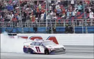  ?? Chris Graythen / Getty Images ?? Denny Hamlin celebrates with a burnout after winning at Talladega Superspeed­way on Sunday.