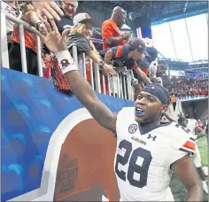  ?? JOHN BAZEMORE — THE ASSOCIATED PRESS ?? Auburn running back JaTarvious Whitlow celebrates with fans after the Tigers defeated Washington in a battle of top-10 teams.
