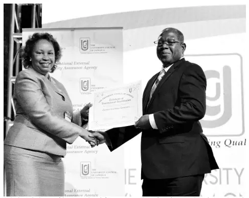  ?? CONTRIBUTE­D ?? Dr Carolyn Hayle, chairman of the University Council of Jamaica, presents the Certificat­e of Institutio­nal Accreditat­ion to Dr Lincoln Edwards, president of Northern Caribbean University, during an awards ceremony held recently at the Iberostar Hotel in Montego Bay, St James.