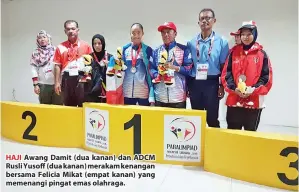  ??  ?? HAJI Awang Damit (dua kanan) dan ADCM Rusli Yusoff (dua kanan) merakam kenangan bersama Felicia Mikat (empat kanan) yang memenangi pingat emas olahraga.