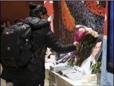  ?? ASSOCIATED PRESS ?? Flowers are laid beside books of condolence before a ceremony Wednesday at Carleton University to honor biology PhD student Fareed Arastech and biology alumnus Mansour Pourjam, who died in the crash of Ukraine Internatio­nal Airlines Flight PS752.