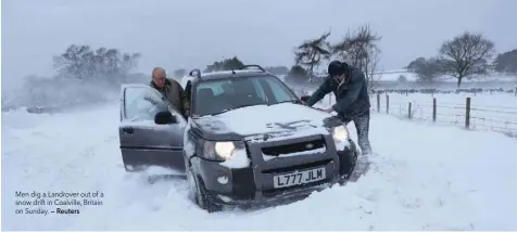  ?? — Reuters ?? Men dig a Landrover out of a snow drift in Coalville, Britain on Sunday.