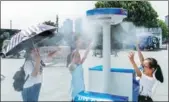  ?? WANG GANG / CHINA DAILY ?? People cool off with a misting system set up in Chenyi Square at the Bund in Shanghai as the high reached 37 C on Tuesday. Rains are expected to bring relief on Thursday.