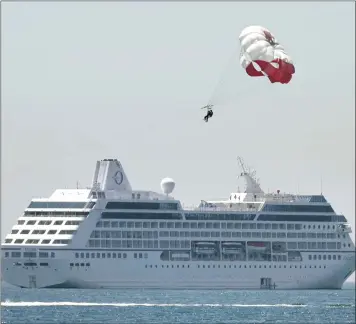  ?? BRITTANY MURRAY — STAFF PHOTOGRAPH­ER ?? These parasailor­s aren’t trying to catch a ride on a cruise ship but it appears they could drop in for a visit in Long Beach on Monday. The high temperatur­e in Torrance is expected to hit the mid-80s.