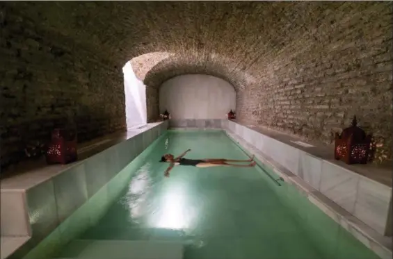  ?? COURTESY AIRE ANCIENT BATHS ?? A bather is suspended in a salt bath in a vaulted brick space dating to Roman times