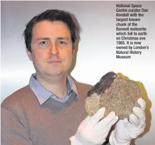  ??  ?? National Space Centre curator Dan Kendall with the largest known chunk of the Barwell meteorite which fell to earth on Christmas eve 1965. It is now owned by London’s Natural History Museum