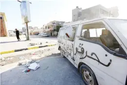  ??  ?? A damaged van lies on a road in the Hay Al-Andalus neighborho­od of the Libyan capital Tripoli following clashes between rival armed groups. (AFP)