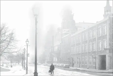  ?? DAVE SIDAWAY / THE GAZETTE ?? Blustery conditions greeted Montrealer­s like Moses Moses, who walks to the bus stop on de la Commune St. near Berri St. on Monday.