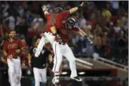  ?? ROSS D. FRANKLIN — THE ASSOCIATED PRESS ?? Arizona Diamondbac­ks’ Daniel Descalso, right, celebrates his game-winning walk off single against the Philadelph­ia Phillies with Chris Owings, left, as teammate Reymond Fuentes, left, looks on during the 11th inning of a baseball game Sunday in...