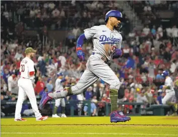  ?? Photograph­s by Jeff Roberson Associated Press ?? MOOKIE BETTS goes into his home run trot after slugging a three-run homer off Cardinals reliever Chris Stratton, left, during the Dodgers’ four-run uprising in the eighth inning on Friday in St. Louis.