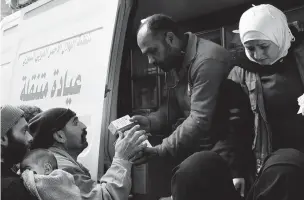  ??  ?? Members of the Syrian Red Crescent distribute medicines for civilians Monday in Douma, eastern Ghouta, a suburb of Damascus.