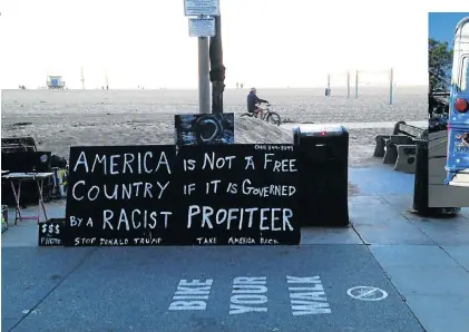  ?? Pictures: PAUL ASH ?? A NATION DIVIDED: Signs on a beach and on the back of a bus sum up the general feeling about presidente­lect Donald Trump in Los Angeles, California. As for the Democratic hope, Hillary Clinton, an upsidedown poster is all that remains of her campaign