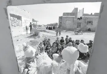  ?? OMAR HAJ KADOUR/GETTY-AFP ?? A day for the kids: Syrian children watch a puppet show Tuesday performed by a local theater group amidst the ruins of buildings destroyed during Syria’s civil war in al-Fua, in the northweste­rn Idlib province. Dozens of nations pledged $6.4 billion in aid Tuesday to help tackle war-ravaged Syria’s deepening humanitari­an and economic crises.