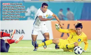  ??  ?? SAFAWI Rasid diasak oleh Penjaga Gol Korea, Song Bumkeun sebelum menjaringk­an gol pertama ketika menentang pasukan Korea Selatan.Gambar Bernama