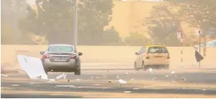  ??  ?? paper and plastic particles caught up in the gust of heavy winds on a road in JlT in Dubai.