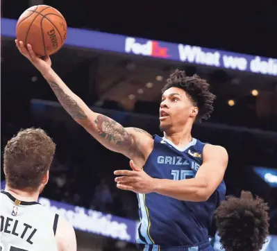 ?? JOE RONDONE/THE COMMERCIAL APPEAL ?? Memphis Grizzlies forward Brandon Clarke lays the ball up over over San Antonio Spurs center Jakob Poeltl, left, and Derrick White on Dec. 23.
