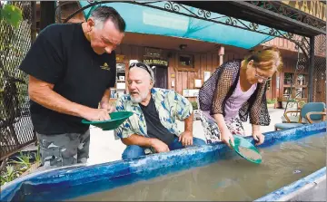  ?? DAN HONDA — BAY AREA NEWS GROUP ?? Gary Finch, left, helps teach Wayne Bergstrom, center, of Clear Lake Oaks, and Berit Kristianse­n, right of Norway, how to properly pan for gold outside of Gold Prospectin­g Adventures located on historic Main Street in Jamestown.