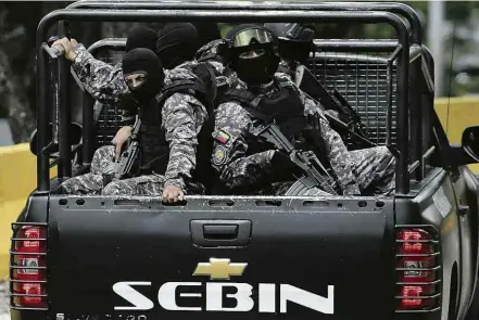  ?? Fernando Llano/Associated Press ?? Agentes do Serviço Bolivarian­o de Inteligênc­ia (Sebin) participam de operação contra o grupo armado de Óscar Pérez