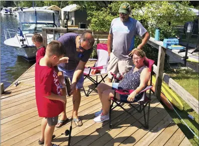  ?? PHOTOS BY CHAD FELTON — THE NEWS HERALD ?? Seven-year-old Denny Meyer Jr. holds up his catfish as Art Carina takes a measuremen­t on Aug. 28during the inaugural Mentor PerchFest at Mentor Lagoons Nature Preserve and Marina.