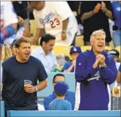  ?? Mark J. Terrill Associated Press ?? DODGERS CO-OWNERS Todd Boehly, left, and Mark Walter, right, bought a minority share of the Lakers, creating an option to bundle a sports package.