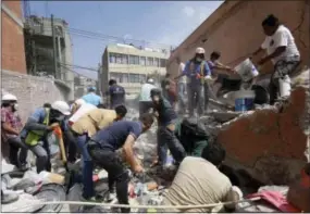  ?? THE ASSOCIATED PRESS ?? Rescue workers and volunteers search for survivors at the Ninos Heroes neighborho­od in Mexico City on Tuesday. A magnitude 7.1 earthquake has stunned central Mexico, killing more than 100 people as buildings collapsed in plumes of dust.