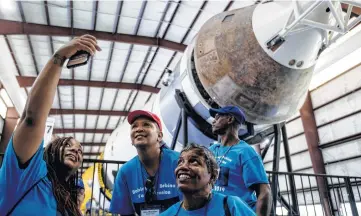  ?? Brett Coomer / Staff photograph­er ?? Fallon Vallai, Ann Minkins and Judith Johnson take a photo in front of a Saturn V at Houston’s Rocket Park.