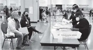  ?? NAM Y. HUH AP ?? Election workers, right, verify ballots as recount observers watch during a hand recount of presidenti­al votes at Milwaukee’s Wisconsin Center on Friday. The recount in Wisconsin’s two-most-heavily Democratic counties began Friday with President Donald Trump’s campaign seeking to discard thousands of absentee ballots it alleges should not have been counted.