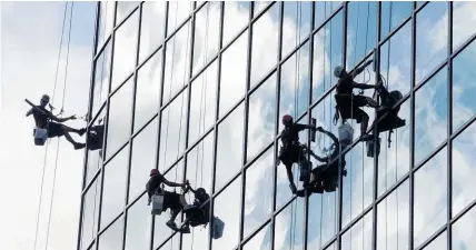  ?? Photo / Greg Bowker ?? Are tower window washers’ glimpses into other people’s lives a perk or horror of the job?