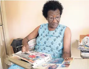  ?? GLADSTONE TAYLOR/PHOTOGRAPH­ER ?? Regina Hanson flips through pages of a photo album recalling memories of her son, slain Constable Leighton Hanson.