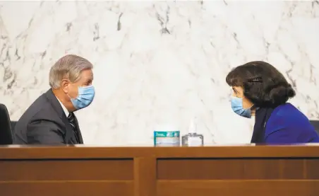  ?? Kevin Dietsch / Associated Press ?? Sen. Dianne Feinstein, DCalif., speaks with Sen. Lindsey Graham, RS. C., before a confirmati­on hearing for Supreme Court nominee Amy Coney Barrett before the Senate Judiciary Committee on Monday. Feinstein attended the hearing in person.