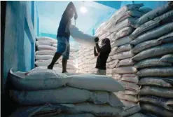  ?? — Reuters ?? Labourers lift a sack filled with sugar to load it onto a handcart at a wholesale market in Kolkata, India.