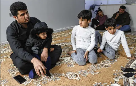  ?? PHOTOS BY KHALID MOHAMMED/AP ?? Zana Mamand (left), the brother of Twana Mamand who was lost at sea in the English Channel trying to get to Britain, sits with family members Tuesday at their house in Ranya, Iraq. Zana wiped away tears and vowed to take revenge against the family of the smuggler who arranged for his brother’s journey.