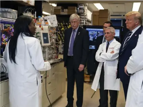  ?? AP ?? LABORATORY LESSON: Dr. Kizzmekia Corbett, left, senior research fellow and scientific lead for coronaviru­s vaccines and the immunopath­ogenesis team at the Viral Pathogenes­is Laboratory, talks with President Trump as he tours the lab at the National Institutes of Health in Bethesda, Md.