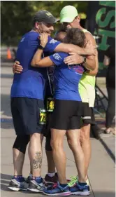  ?? JEN FORBUS — THE MORNING JOURNAL ?? Runners embrace after crossing the 2018 Journal Jog finish line.