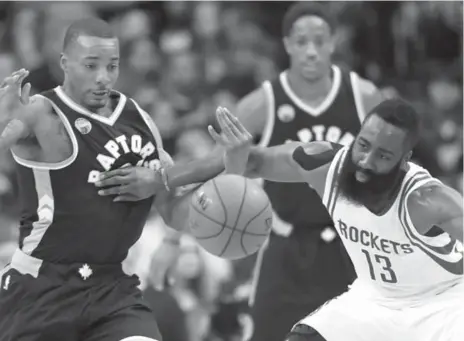  ?? DAVID J. PHILLIP/THE ASSOCIATED PRESS ?? The Rockets’ James Harden battles the Raptors’ Norm Powell for a loose ball during first-half action Friday in Houston. Harden posted a triple-double.